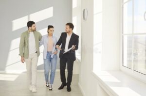 agente immobiliare mostra casa a clienti felici 1