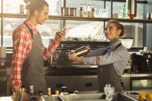 Qual è Lo Stipendio Medio di Un Barista 5° Livello in Italia 2 barista al lavoro con caffe e registratore