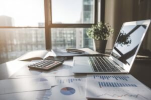 Come Funziona il Regime Forfettario per le Partite IVA 40 bilancia e calcolatrice su scrivania luminosa