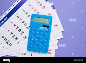 calcolatrice accanto a calendario mensile colorato