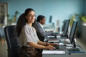donna sorridente al computer in ufficio moderno