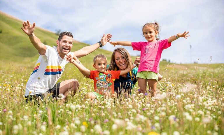 Come Funziona L'Assegno Unico Provinciale A Trento E Chi Ne Ha Diritto 2 famiglie felici con bambini in un parco trentino