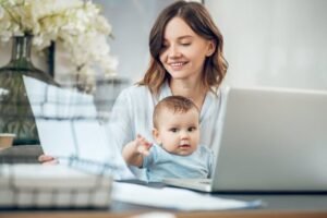 mamma felice con neonato e computer portatile