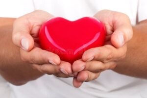 mani che donano una cuore rosso