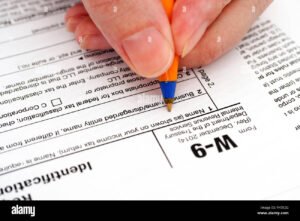 mano che compila modulo fiscale con penna