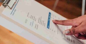 persona che compila una fattura cartacea