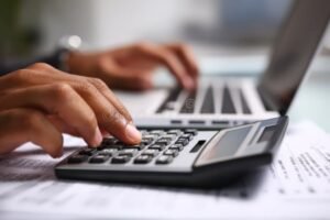 persona che lavora al computer con calcolatrice