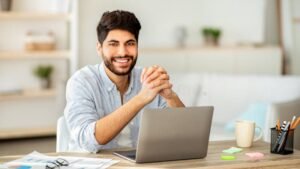 persona felice che usa computer e documenti