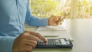 persona seduta al tavolo con calcolatrice