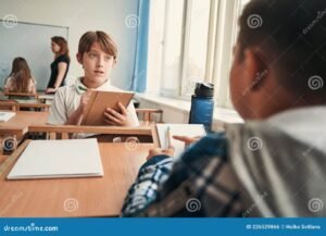 studente che risponde a questionario su tavolo